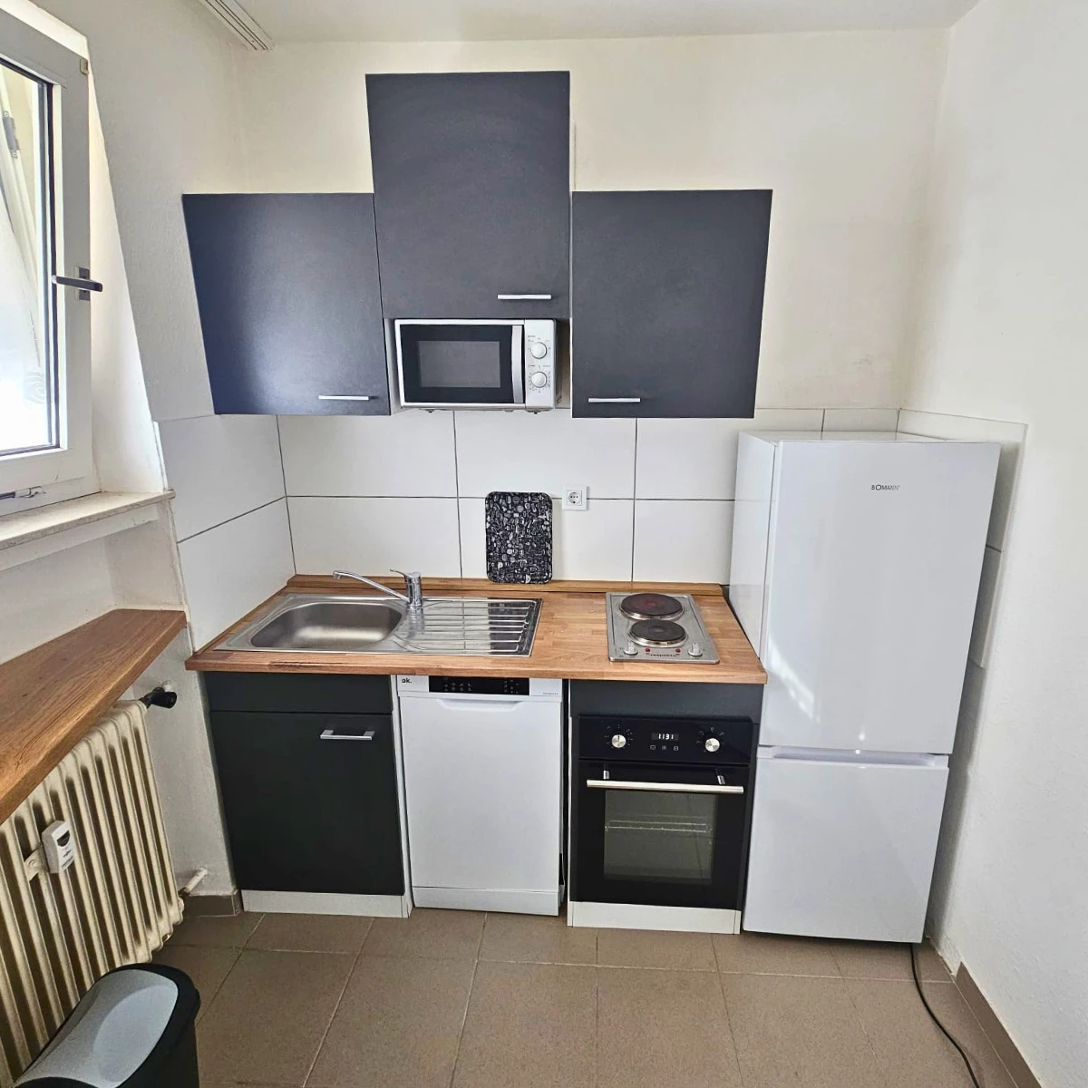 Küchenzeile mit Kühlschrank, Herd, Spülmaschine und Mikrowelle